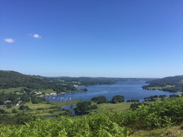 Gorgeous lake view in the Lake District surrounded by greenery around the deep blue water.